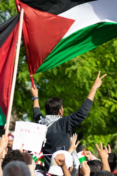 People in the black jacket with red, blue and yellow umbrella
